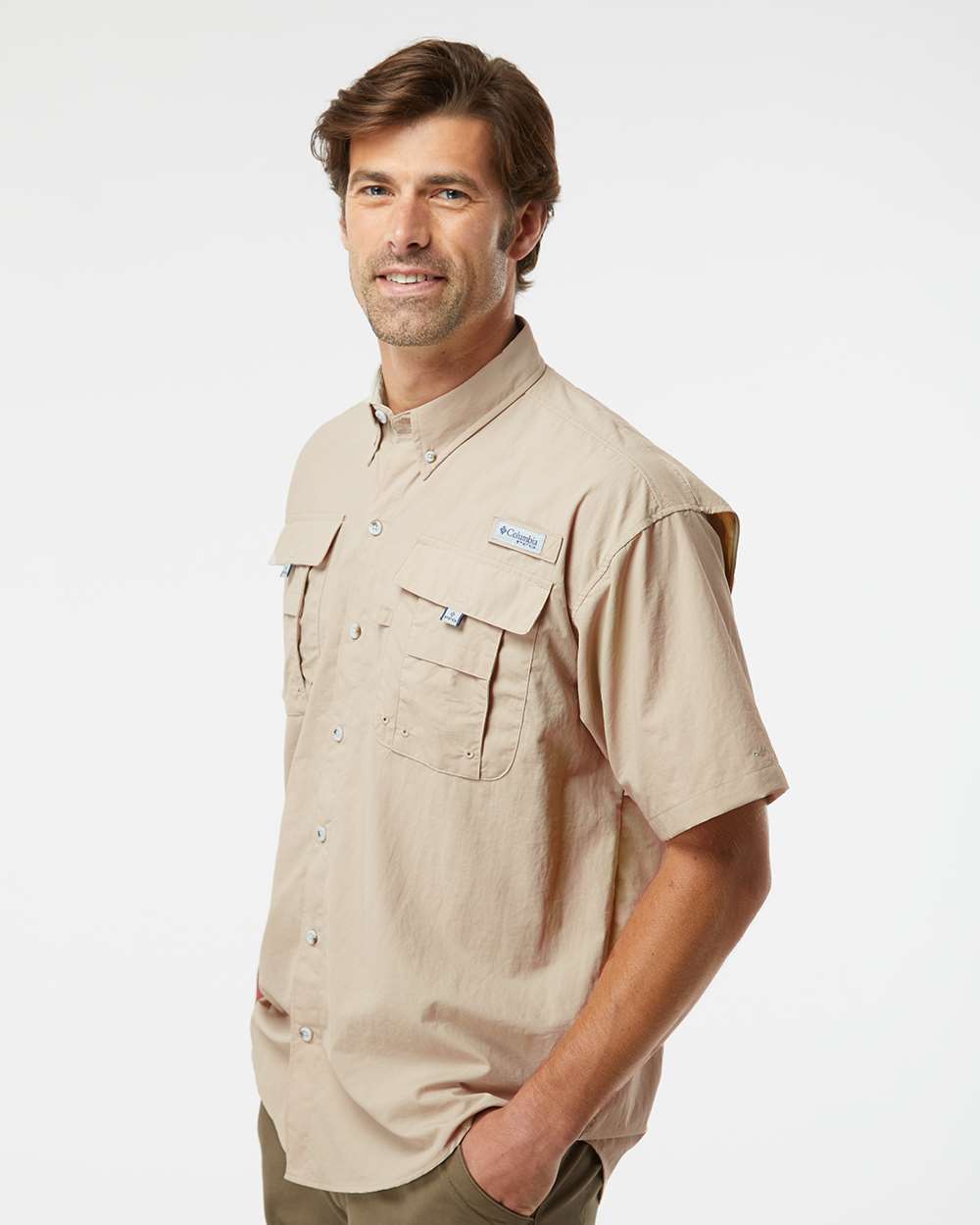 Man wearing a beige short-sleeve shirt with a brand logo on a white background